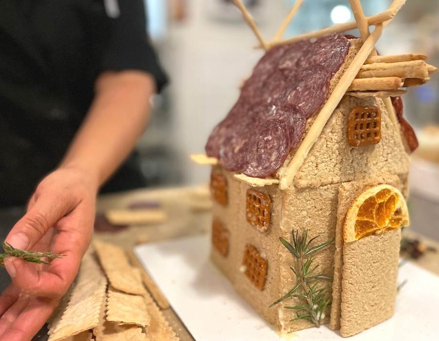 woman building charcuterie chalet in kitchen